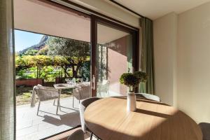 Un comedor con una mesa y un gran ventanal. en Bel Fioeu - by MyHomeInComo, en Menaggio