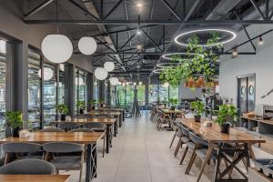 a row of tables and chairs in a restaurant with potted plants at Bukovel Apart in Bukovel