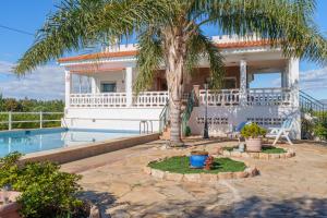 a house with a palm tree and a swimming pool at Masia Miliuca Paraíso rural a un paso de Valencia - Rural paradise close to Valencia in Bétera