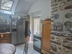 Una cocina con refrigerador de acero inoxidable y una mesa. en Chez Vallye, en Maxent