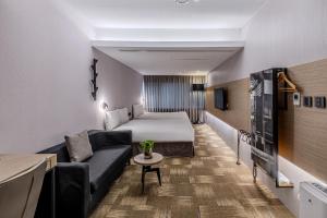 台中市にあるRetro Taichungのベッドとソファのあるホテルの部屋