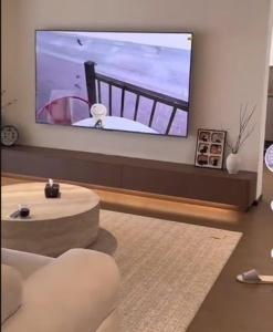 a living room with a large flat screen tv on a wall at 1988 Homestay in Phu Quoc