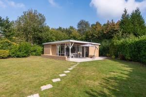 a large yard with a pavilion in a garden at Bungalow Goudhaver | 4 personen - Vakantiepark De Kremmer in Gasselte