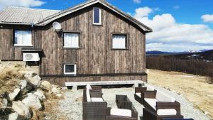 a wooden house with chairs in front of it at Simple Cabin Life In This Nature Cabin in Uvdal +18 photos