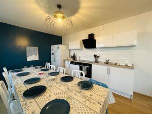 a dining room with a table with chairs and a kitchen at Casa Grand Groupe in Sorges