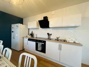 a kitchen with white cabinets and a white refrigerator at Casa Grand Groupe in Sorges