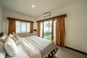 Un dormitorio con una cama y una ventana grande en The Dewi Pererenan Boutique Villa, en Tumbak Bayuh 168 fotos más
