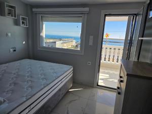 a bedroom with a bed and a view of the ocean at Apartments Nera Paralia-Apartment with sea view in Paralia Katerinis