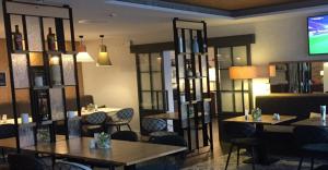 a restaurant with tables and chairs and a flat screen tv at Hotel Am Fischmarkt in Rheinberg