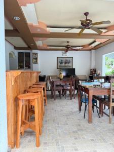 una sala da pranzo con tavoli e sedie in legno di Cozy Stop Inn - Puerto Princesa a Città di Puerto Princesa