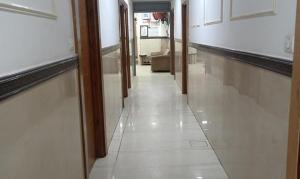 een gang in een gebouw met witte vloeren en muren bij FabHotel The Rivlet Centre in New Delhi
