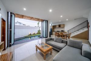 una sala de estar con un sofá y una mesa en The Dewi Pererenan Boutique Villa, en Tumbak Bayuh