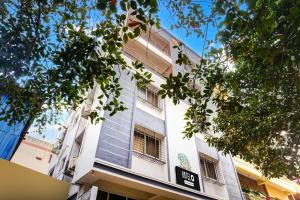 Un edificio alto y blanco con un cartel. en Hotel O Elite Studio, en Kharadi