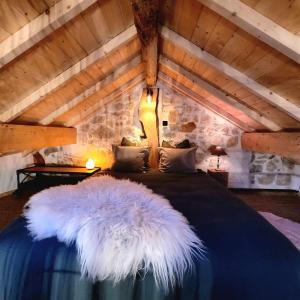 ein Schlafzimmer mit einem großen Bett mit weißer Federmatratze in der Unterkunft La Grange Cal'Ain in Magnieu