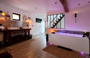 ein großes Bad mit einer großen Badewanne in einem Zimmer in der Unterkunft La Grange Cal'Ain in Magnieu