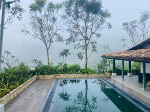 ein Pool in einer Villa mit Blick auf den Wald in der Unterkunft Rain Drops Wellness Villa in Mederipitiya
