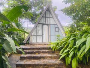een klein huis met een trap daarheen bij Rain Drops Wellness Villa Sinharaja in Mederipitiya