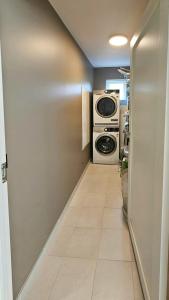 a hallway with a washing machine and a washer and dryer at Hytte Med Havudsigt Nær Kristiansand in Hamresanden