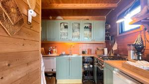 a kitchen with mint green cabinets and a sink at Original Architecture In Southern Norway in Søndeled
