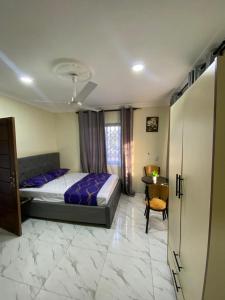 a bedroom with a bed and a table and a desk at Nick Jaaks Courtyard-Single Room in Accra