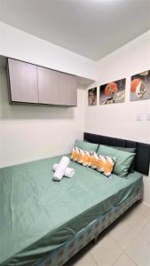 a bedroom with a green bed with two pillows at City View with Balcony at Kasara Residences C5 Pasig in Manila +41 photos