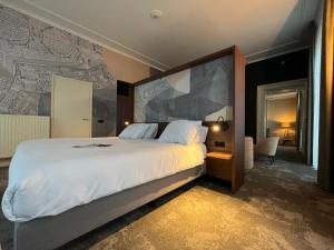 a bedroom with a large bed and a large wall at Fletcher Hotel Paleis Stadhouderlijk Hof in Leeuwarden