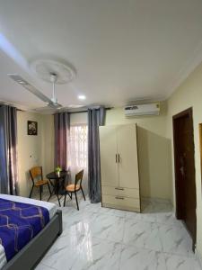 a living room with a bed and a table and chairs at Nick Jaaks Courtyard-Single Room in Accra