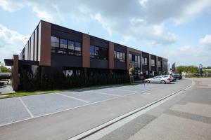 ein Gebäude, vor dem ein Auto geparkt ist in der Unterkunft 24Seven Hotel Schwabach in Schwabach