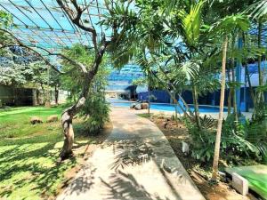 a garden with a palm tree and a walkway at City View with Balcony at Kasara Residences C5 Pasig in Manila +41 photos