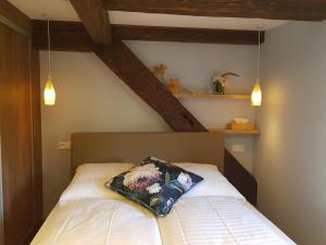 a bedroom with a bed with a pillow on it at L'ESCALE d'ALSACE in Lièpvre