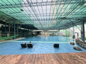 a person sitting in the middle of a large swimming pool at City View with Balcony at Kasara Residences C5 Pasig in Manila