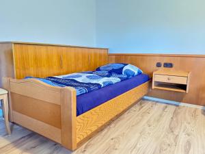 a bedroom with a bed with a wooden headboard at Hotelkamer voor drie personen op de begane grond - 33-5 in Bunkenburg