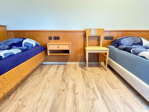 a room with two beds and a chair and a desk at Hotelkamer voor drie personen op de begane grond - 33-5 in Bunkenburg +6 photos