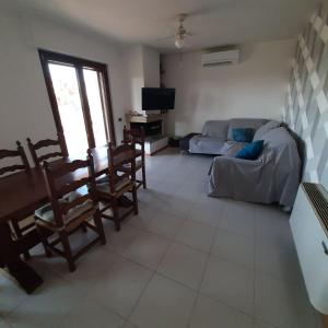 een woonkamer met een bank, een tafel en stoelen bij La casa sul lago dorato in Magione