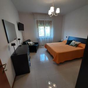 een slaapkamer met een bed en een bank bij La casa sul lago dorato in Magione