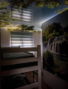 a bedroom with a large painting on the wall at Apartman JakšićS&M in Šid