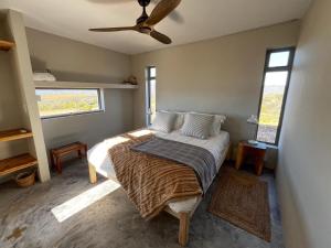 a bedroom with a bed and a ceiling fan at Windvogels in Barrydale