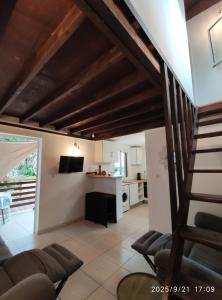 ein Wohnzimmer mit Treppe und Küche in der Unterkunft Ô Chalet in Saint-Philippe
