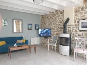 a living room with a blue couch and a fireplace at Les Coquelicots classé 3 étoiles in Paimpol