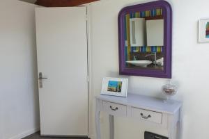 a bathroom with a mirror and a dresser at Les Coquelicots classé 3 étoiles in Paimpol +32 photos