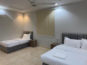 ein Hotelzimmer mit zwei Betten und einem Spiegel in der Unterkunft ركن صحاري للشقق المخدومة 6 جدة Rukn Sahari For Served Apartments in Quai + 118 Fotos