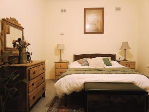 ein Schlafzimmer mit einem Bett, einer Kommode und einem Spiegel in der Unterkunft My River Retreat in Murray Bridge + 22 Fotos