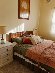 ein Schlafzimmer mit einem Bett und eine Kommode mit einer Lampe in der Unterkunft My River Retreat in Murray Bridge