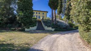 eine Treppe, die zu einem gelben Haus an einer Straße führt in der Unterkunft Villa Palazzaccio 26, Emma Villas in Arezzo