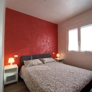 ein Schlafzimmer mit einem Bett und einer roten Wand in der Unterkunft Nirvana's Home 1 near Venice in Noale + 37 Fotos