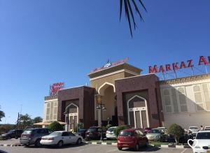 um estacionamento com carros estacionados em frente a um mercadoagênciaagência em Near Airport Rooms em Mawāliḩ