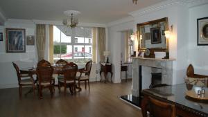 a living room with a dining room table and a fireplace at Rockville in Cashel
