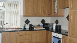 a kitchen with wooden cabinets and a microwave at Rockville in Cashel +11 photos