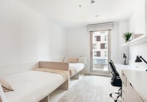Una habitación blanca con dos camas y una ventana. en Soto House Pamplona, en Pamplona