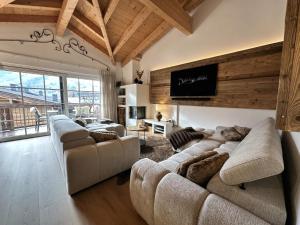 Una sala de estar con sofás y un televisor de pantalla plana. en Penthouse Kaprun Mountain resort A24 by Alpinresort Kaprun, en Kaprun